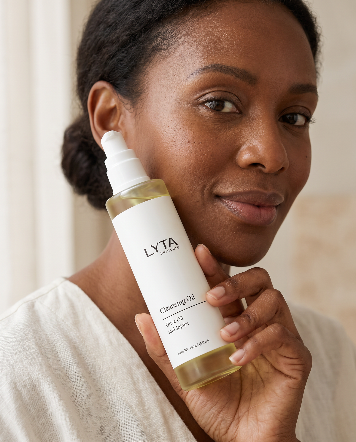 Adult model holding the actual LYTA Cleansing Oil pump bottle