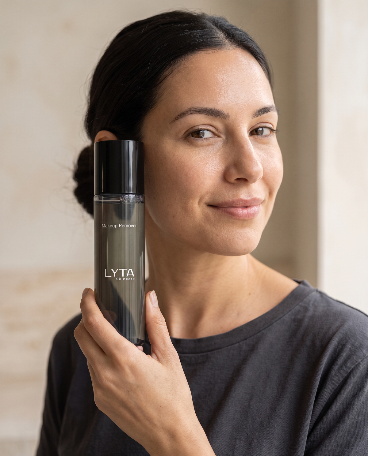 Adult model holding the actual LYTA Makeup Remover bottle
