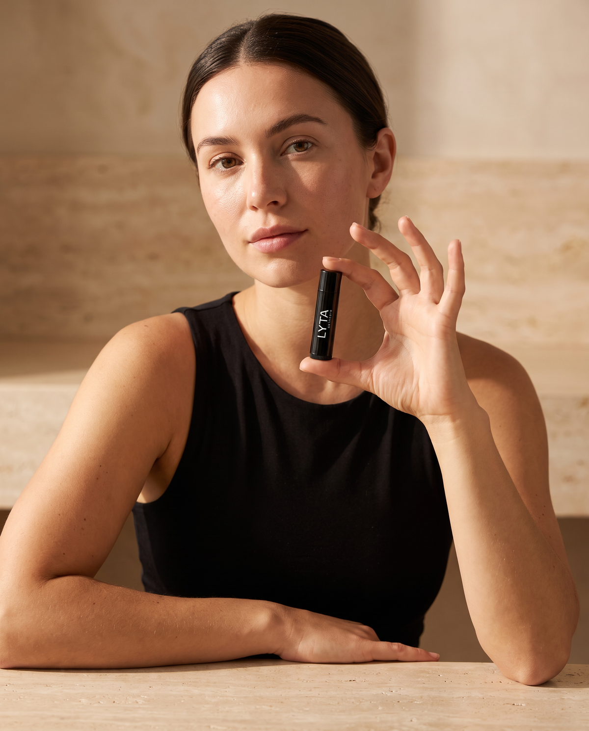 LYTA Vegan Lip Balm, model holding the closed branded tube