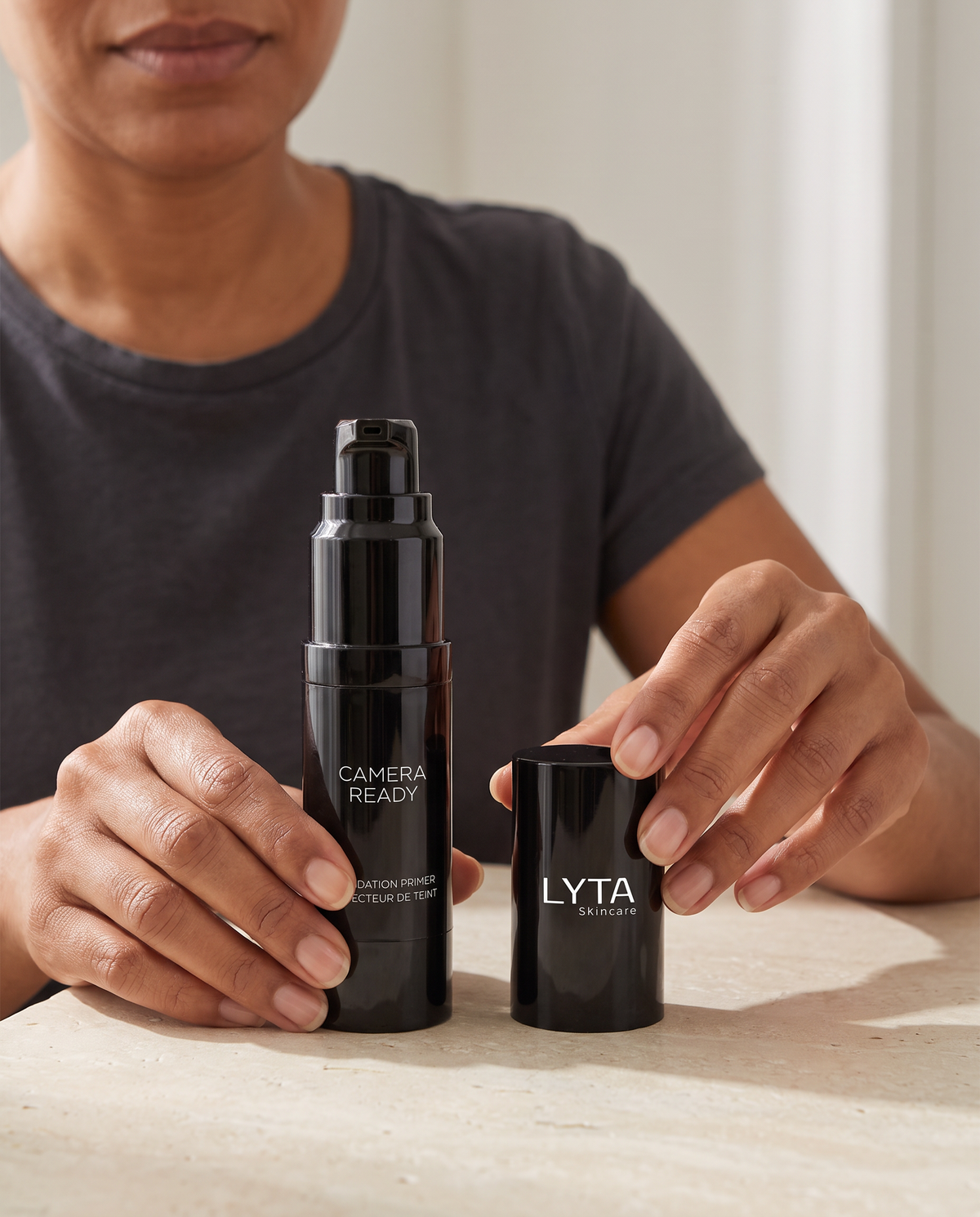 LYTA Foundation Primer Clear, original black pump bottle and branded cap held upright on a stone surface
