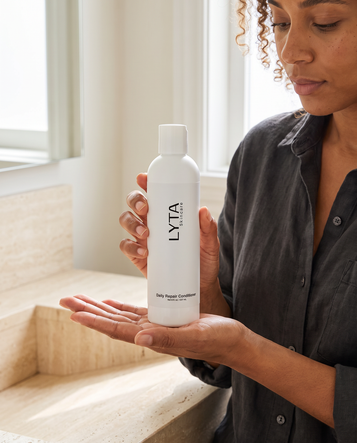 LYTA Daily Repair Conditioner, model holding the exact branded bottle