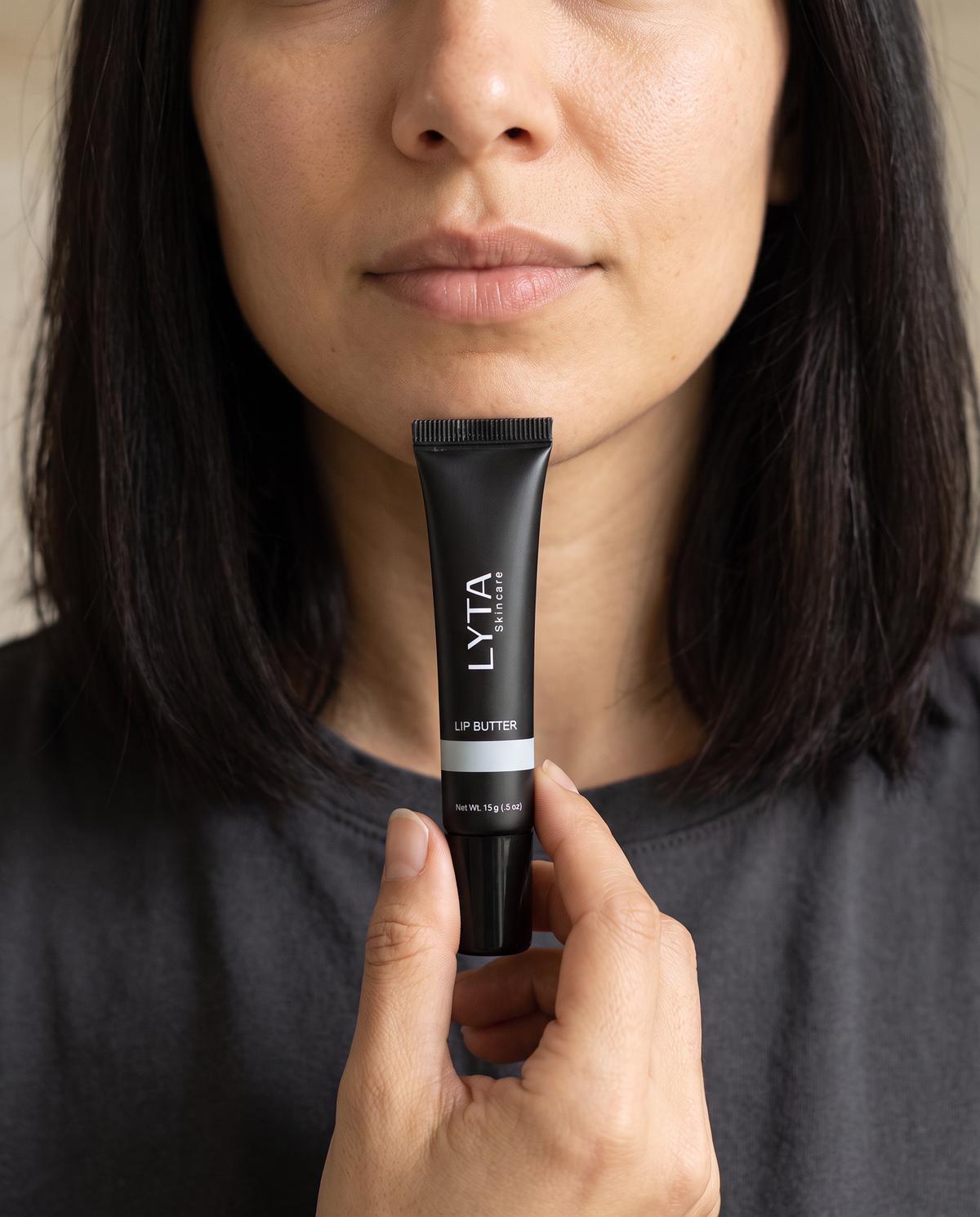 LYTA Lip Butter Pure Butter, model holding the original closed black branded tube