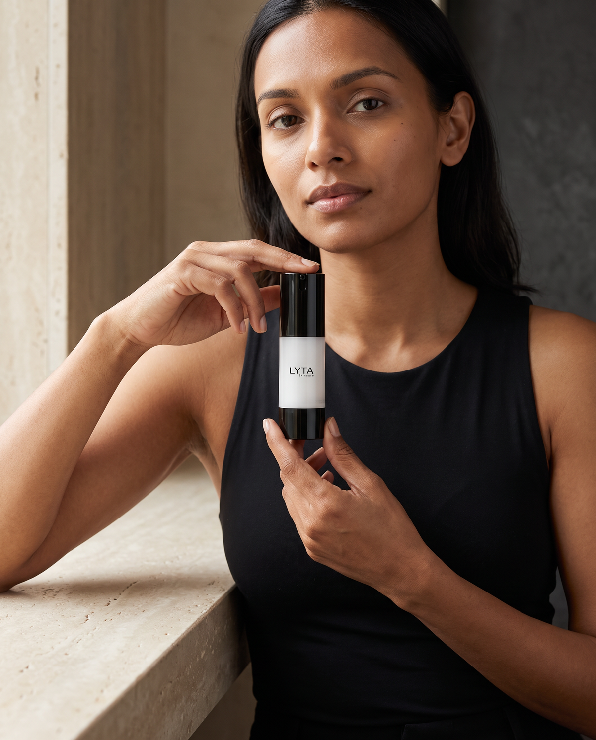 LYTA Soothing Moisturizer, model holding the branded pump bottle